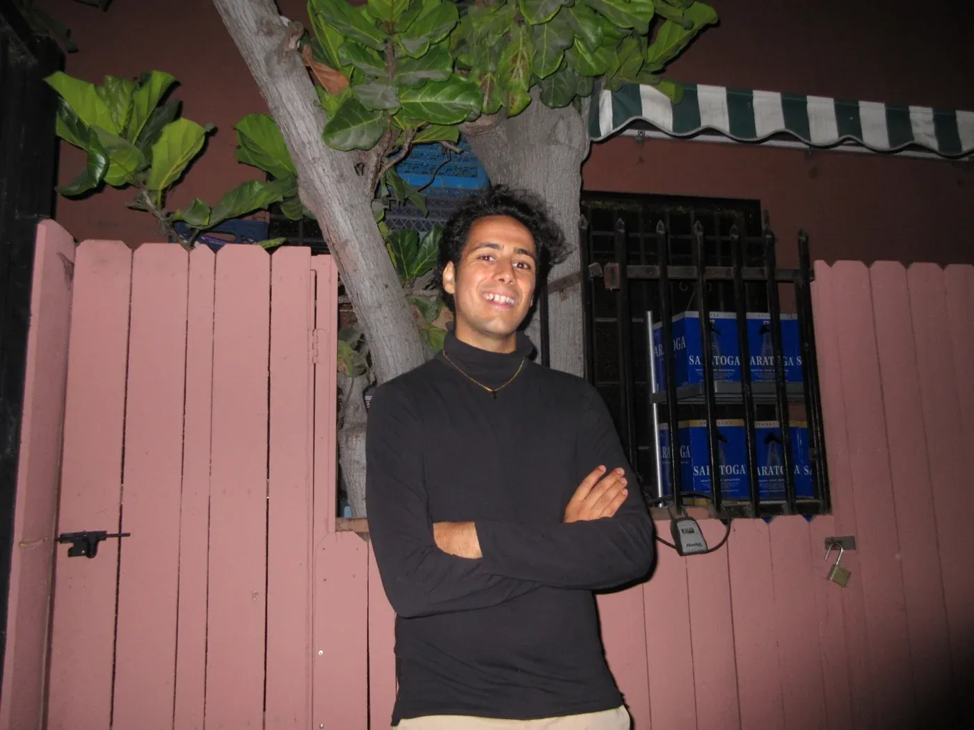 Rosan Sharma smiling, arms crossed, outside at night